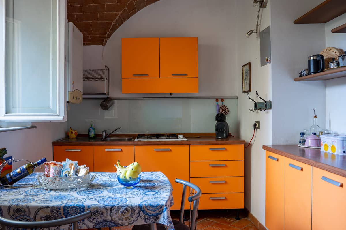 Cucina con piano cottura e tavolo apparecchiato