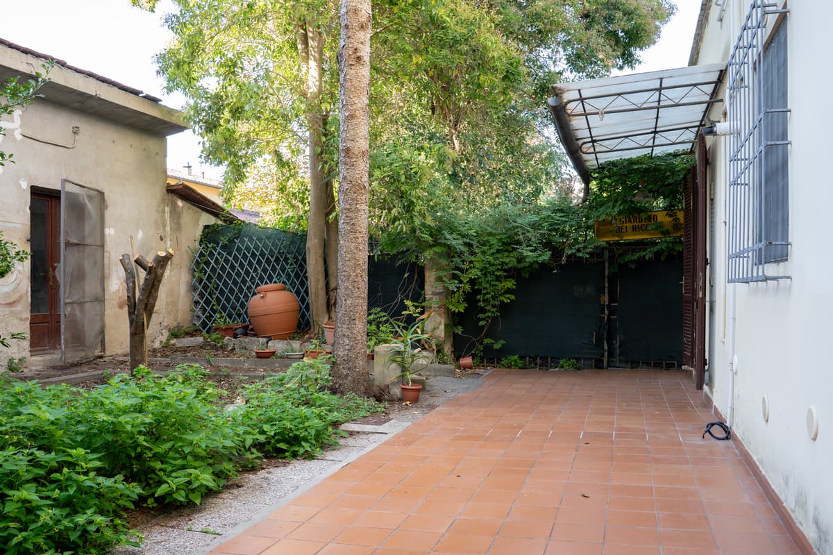 Il giardino privato sul retro, con vialetto e pergola