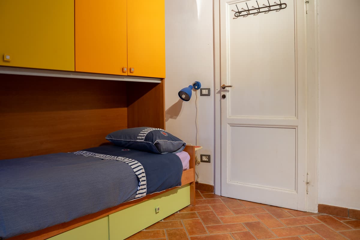Letto singolo accanto alla porta della camera