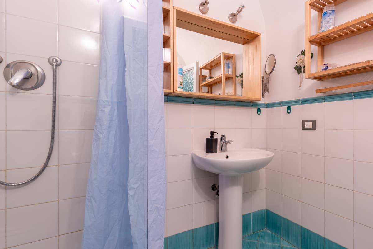 Bagno con doccia e lavabo, piastrelle verde acqua