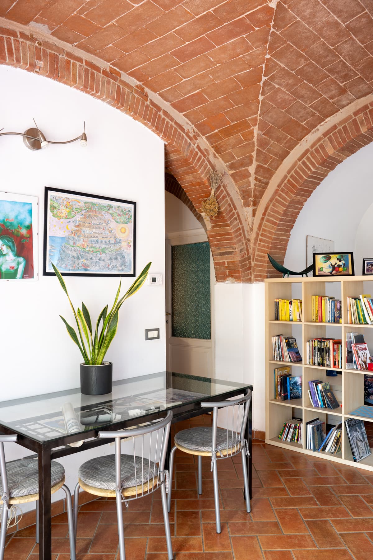Le volte in mattone a vista sopra il tavolo da pranzo e la libreria